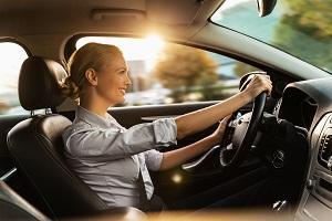 Photo of a beautiful smiling young businesswoman driving car