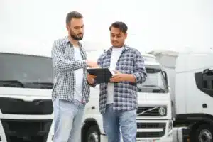 Two men review documents on a clipboard